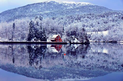 Красный дом на берегу озера снежной осенью