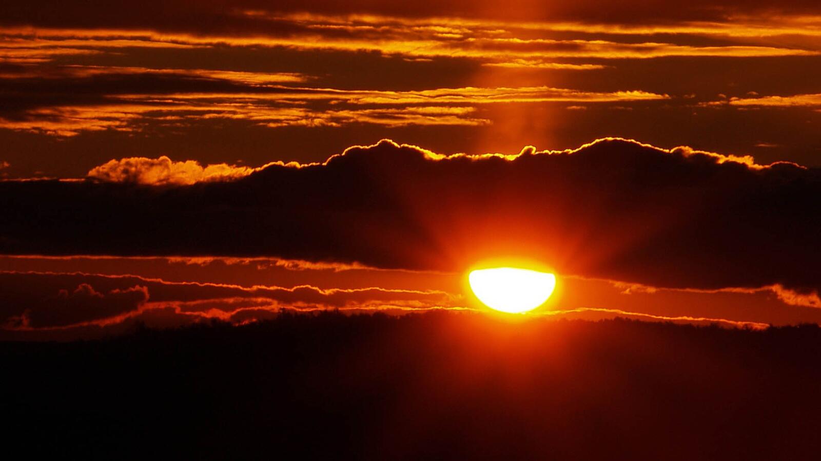 Бесплатное фото Красное солнце в облаках на закате