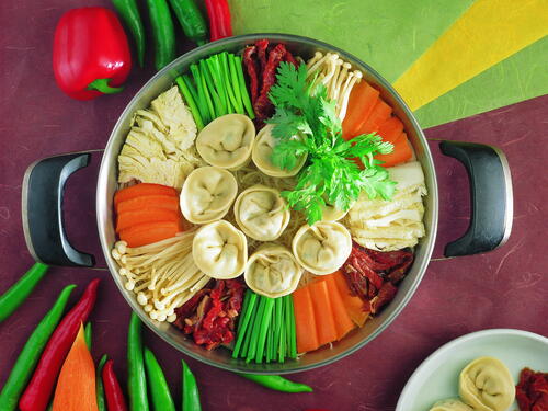 A plate of dumplings with fresh vegetables.
