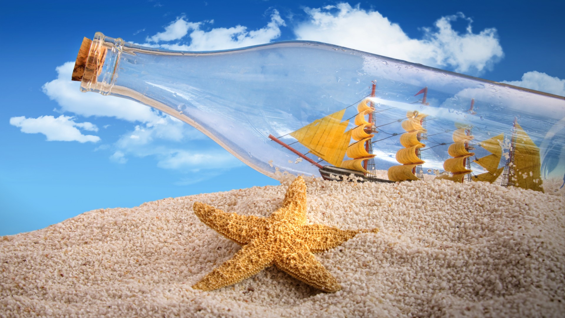 免费照片白沙上躺着一个透明的瓶子，里面装着一艘帆船