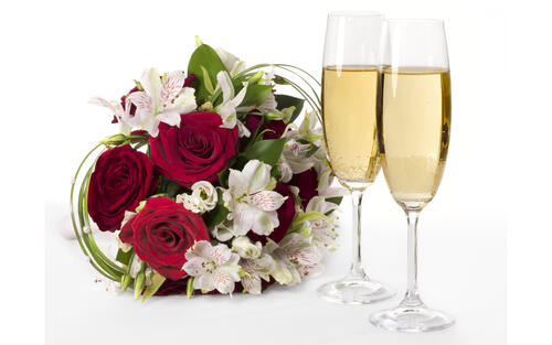 Two champagne glasses and a bouquet of flowers