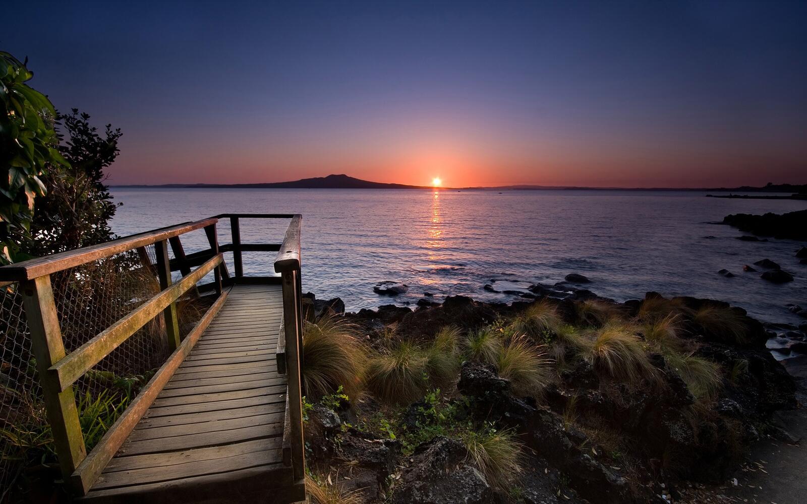 Бесплатное фото Морской закат у деревянного пешеходного мостика