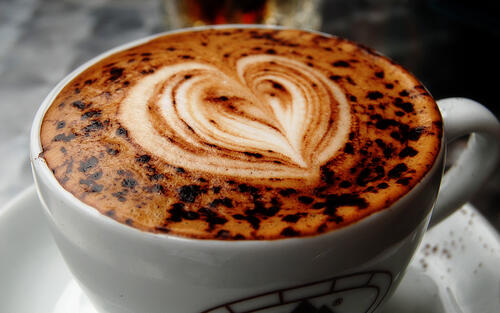 A cup of coffee with a heart on the foam.
