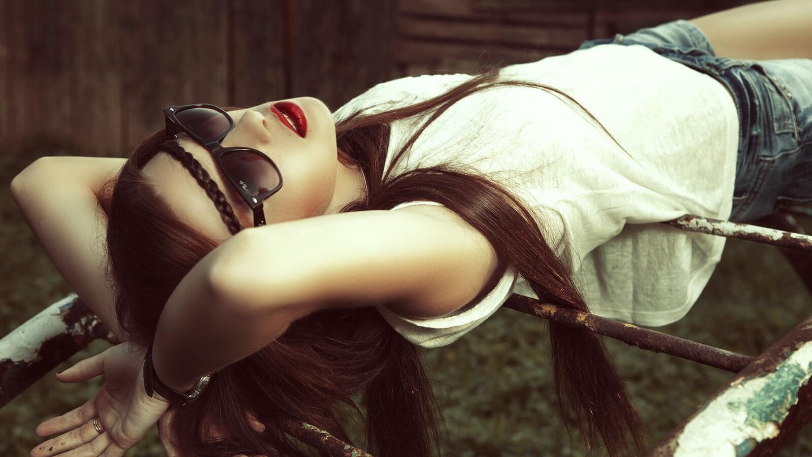 Free photo Girl in sunglasses relaxes lying on her back
