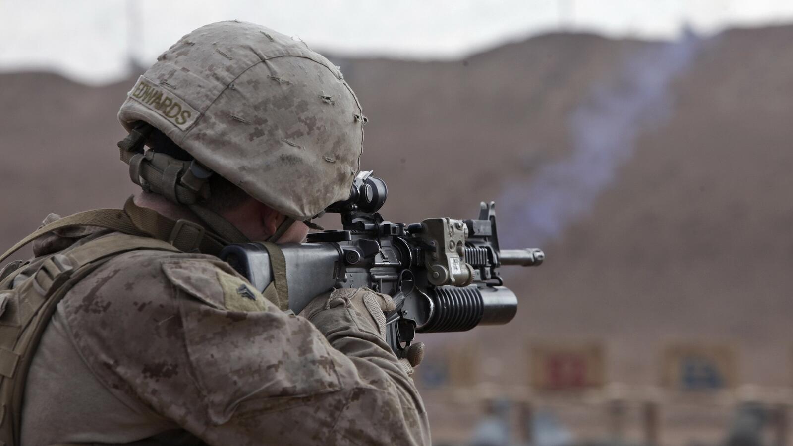 免费照片一名士兵手持自动步枪，枪管下有枪托。