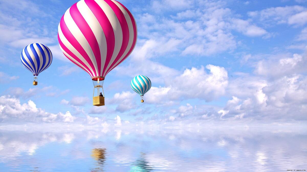 Воздушные шары пролетают над озером