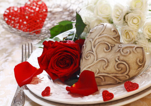 A red rose on a plate for Valentine`s Day.