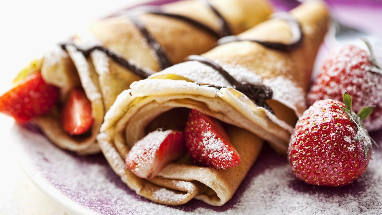 Free photo Pancakes with strawberries and powdered sugar