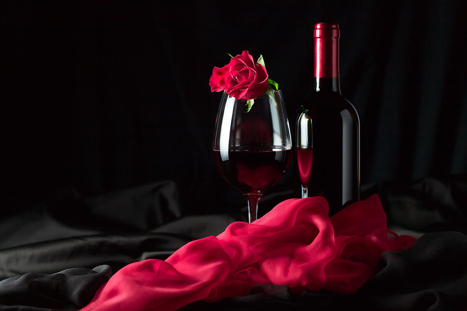 Бесплатное фото Бокал с красным вином и красной розой