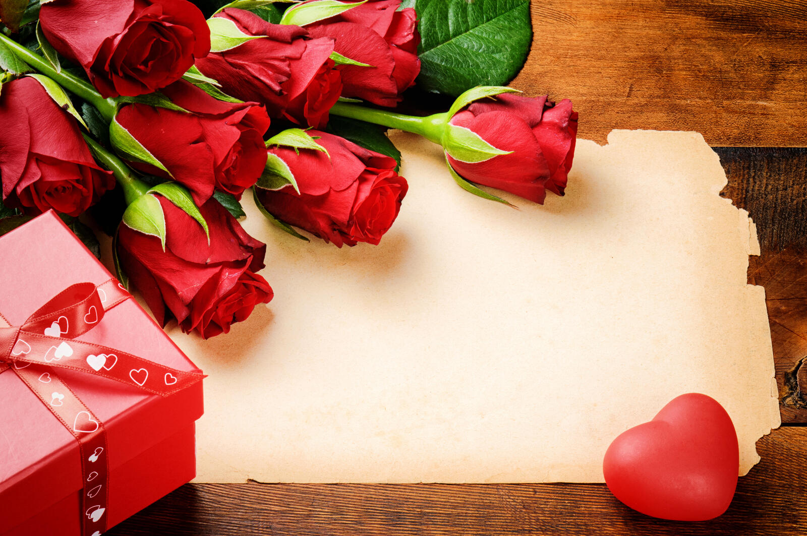Free photo A bouquet of red roses with a letter for Valentine`s Day