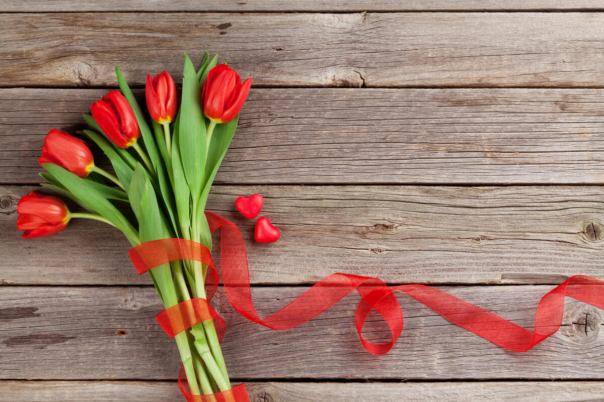 Букет красных тюльпанов на деревянном фоне