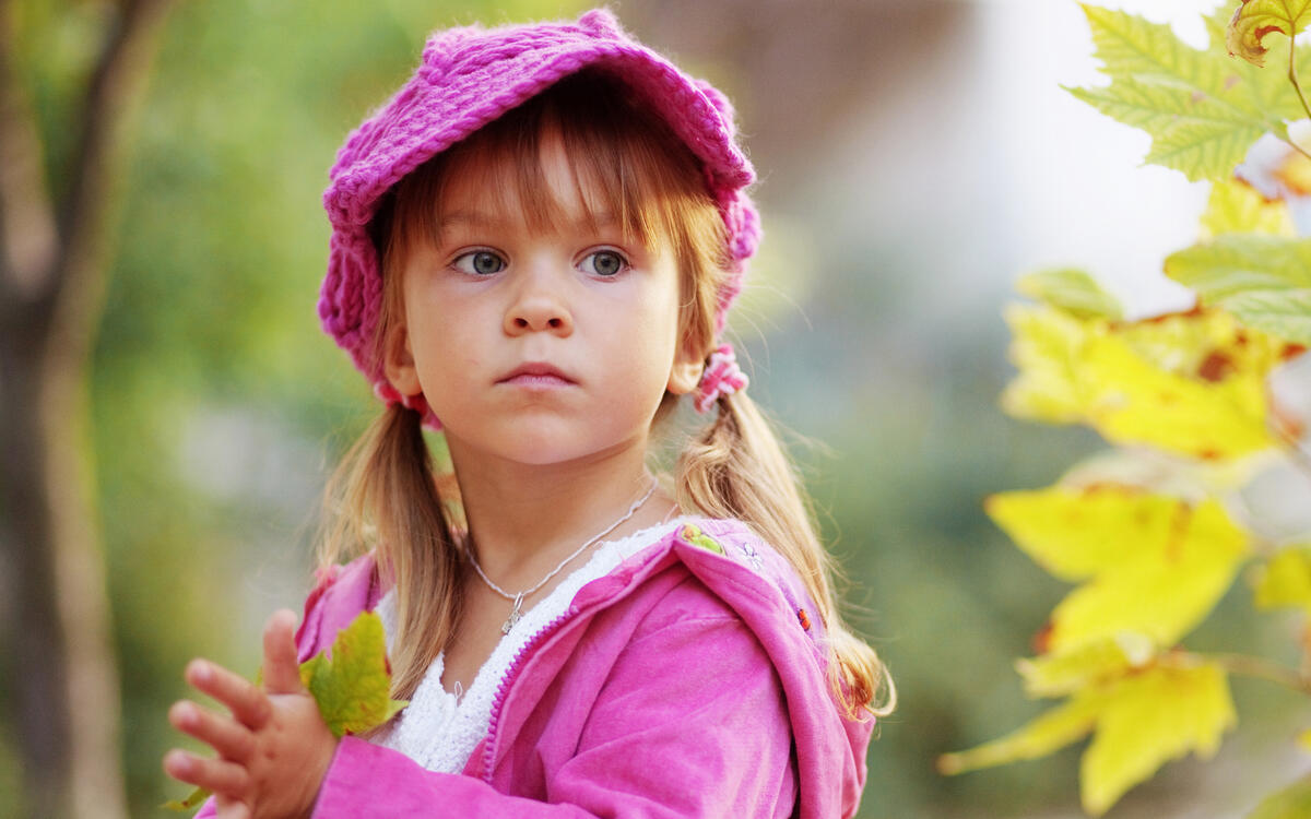 A little girl in a pink knit cap