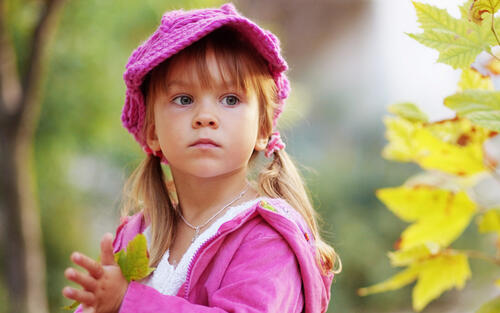 A little girl in a pink knit cap