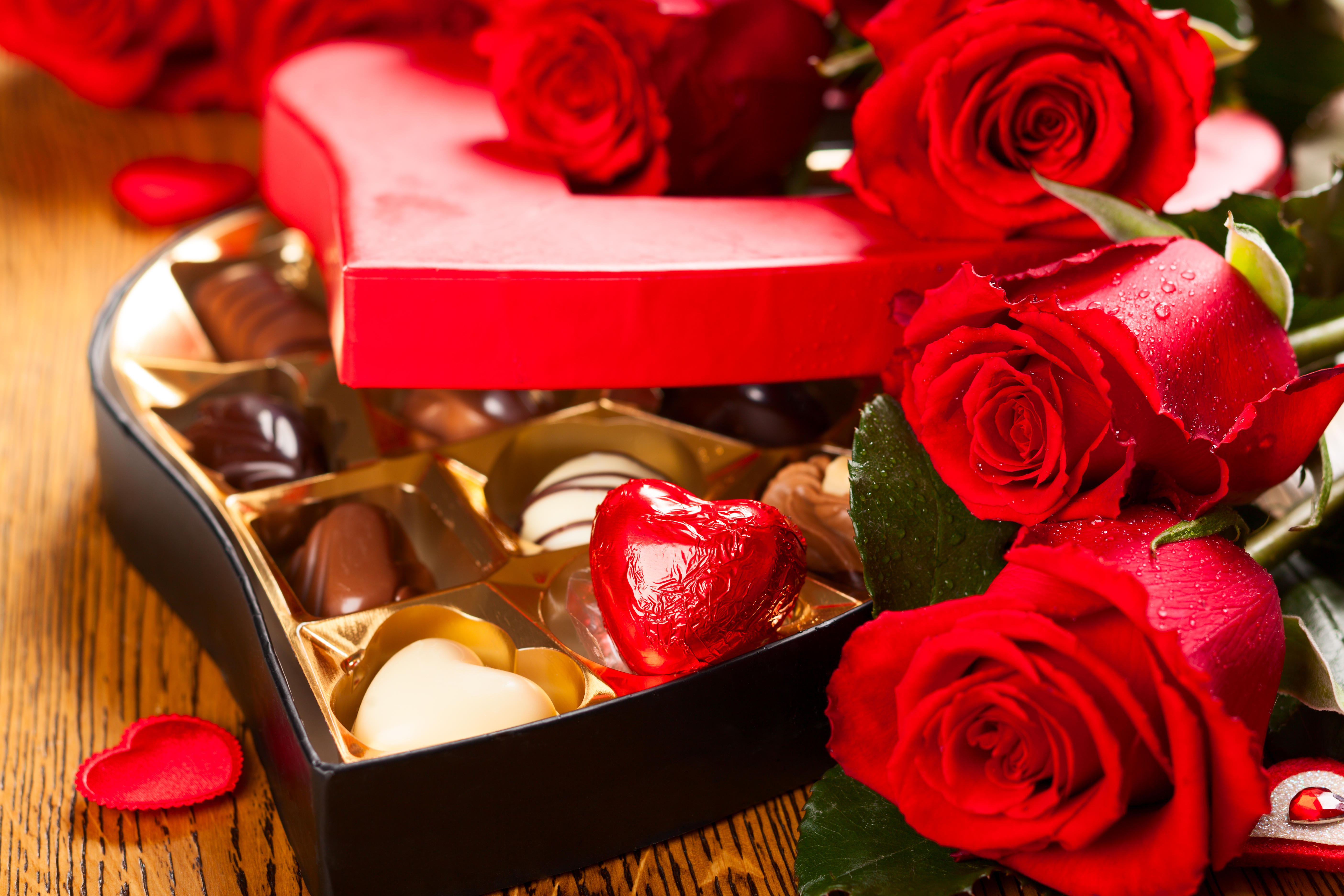 免费照片一盒巧克力旁的红玫瑰