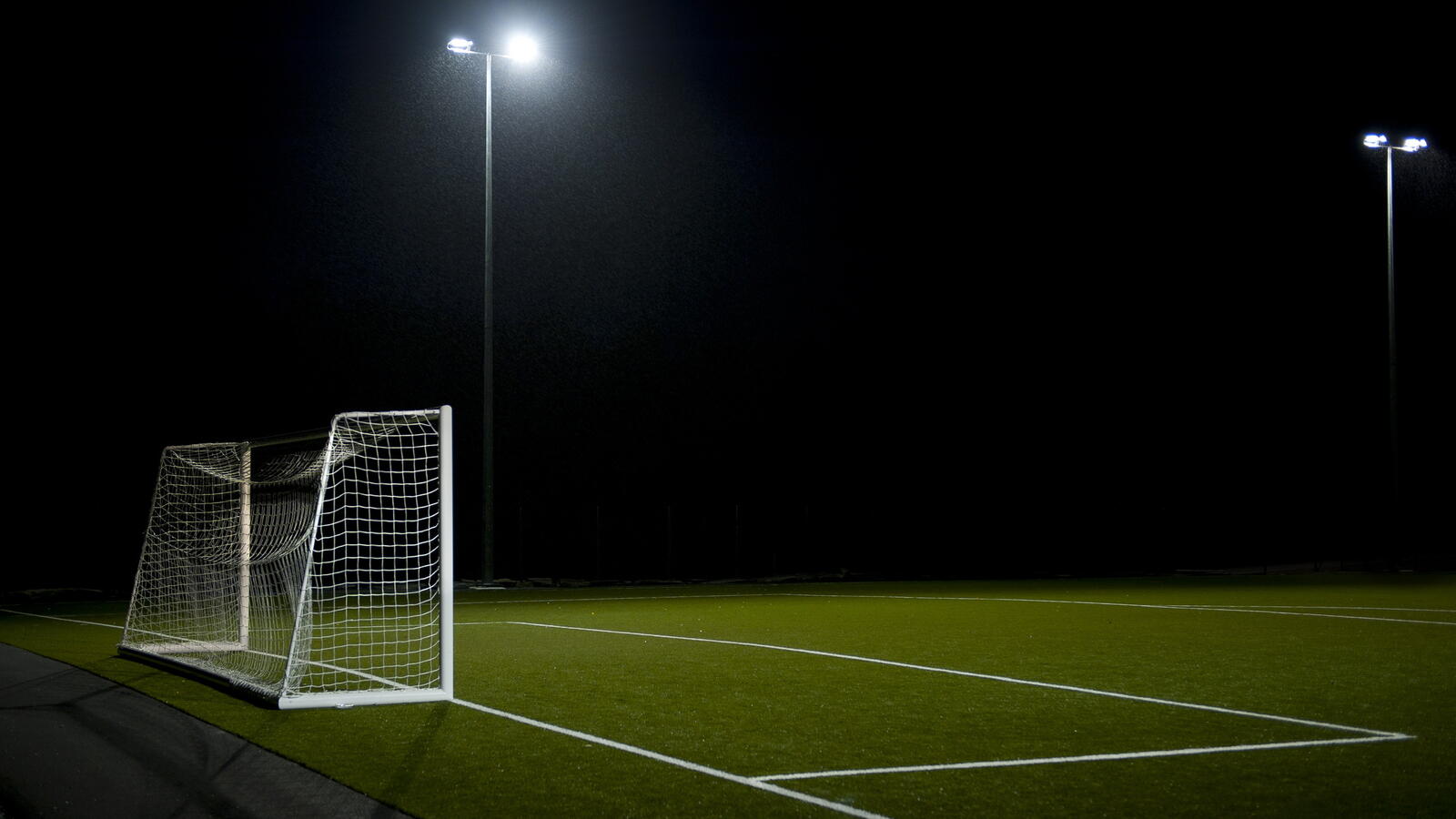 Free photo A soccer field in the night under the streetlights