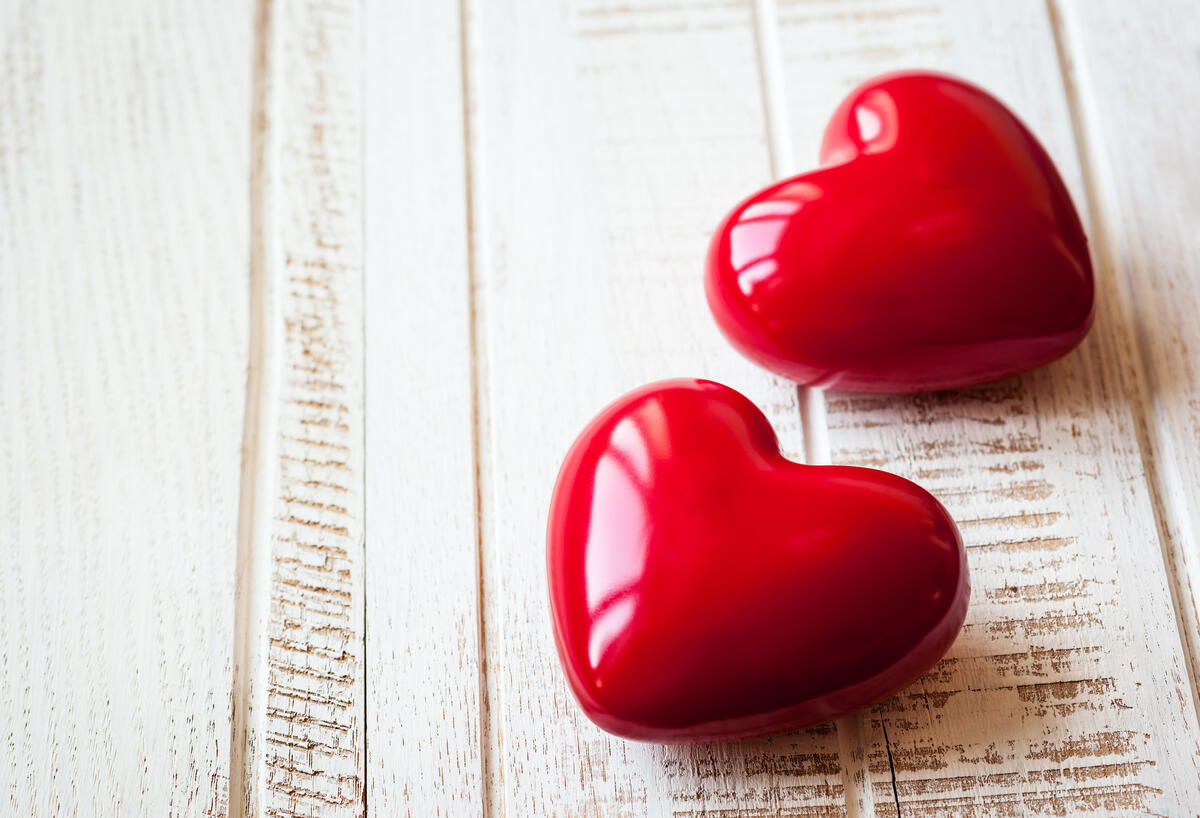 Two red hearts lying on the wooden floor
