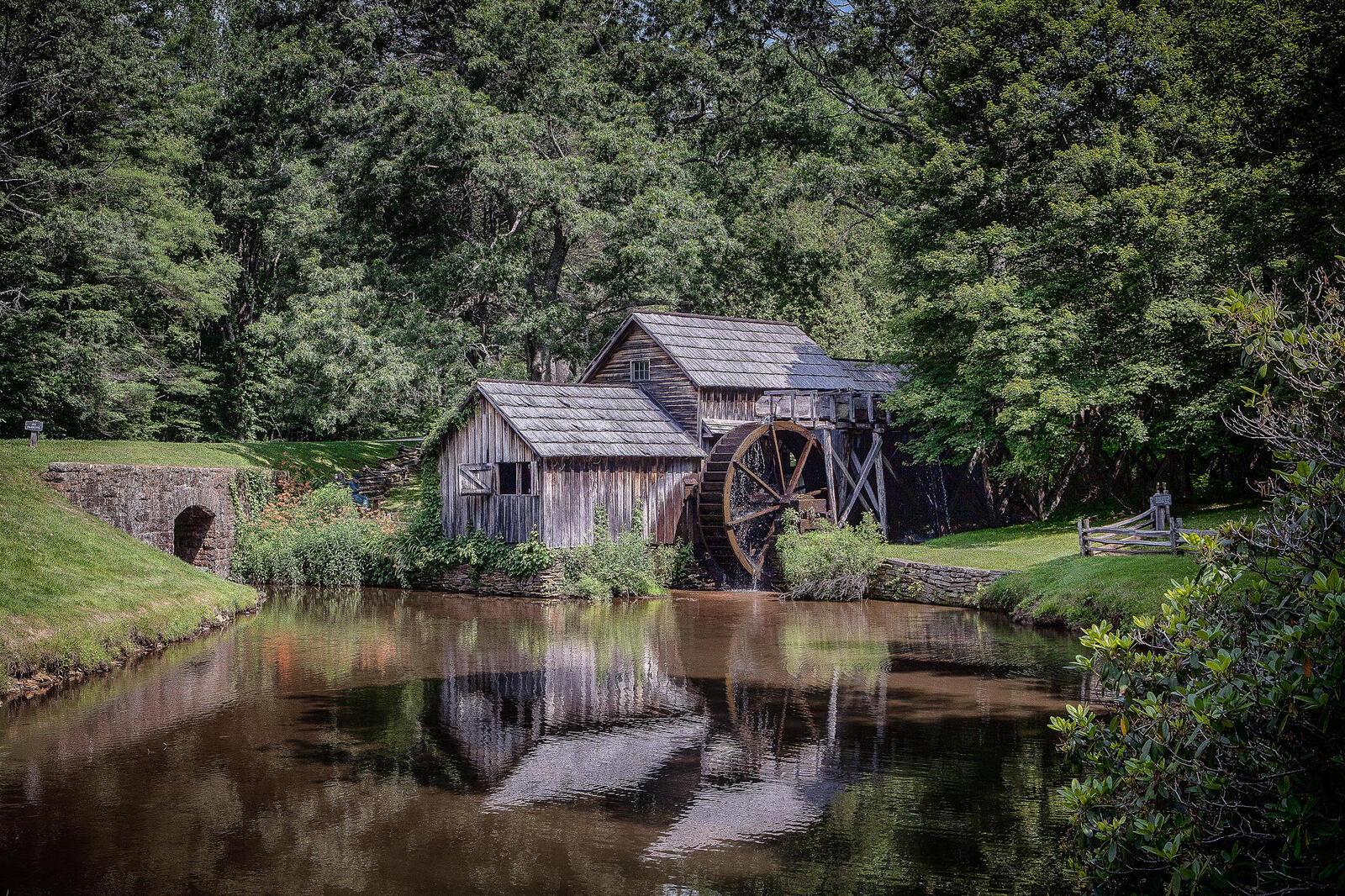 Free photo Watermill on the river by the bridge