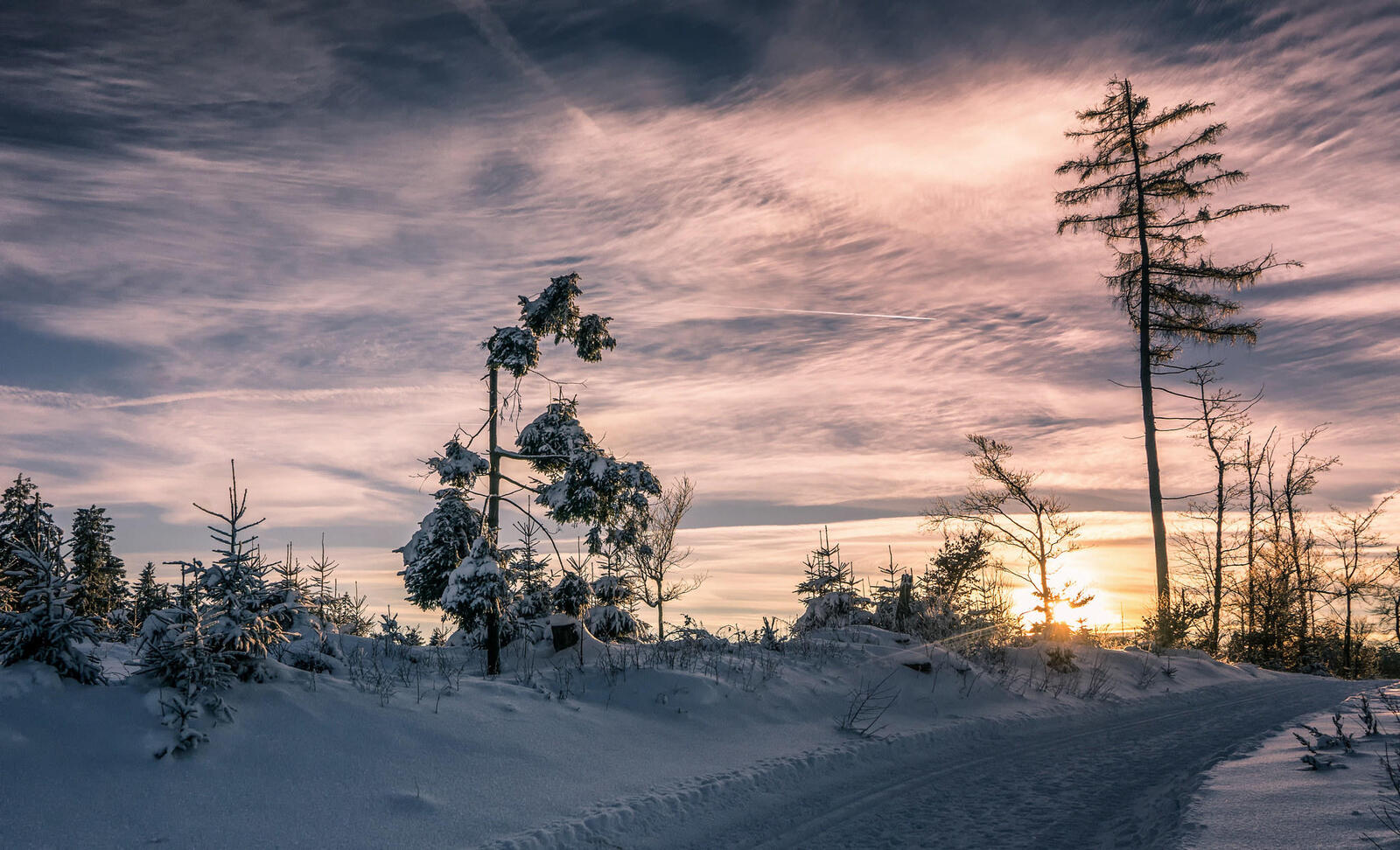 Бесплатное фото Зимняя автомобильная дорога среди сугробов на закате